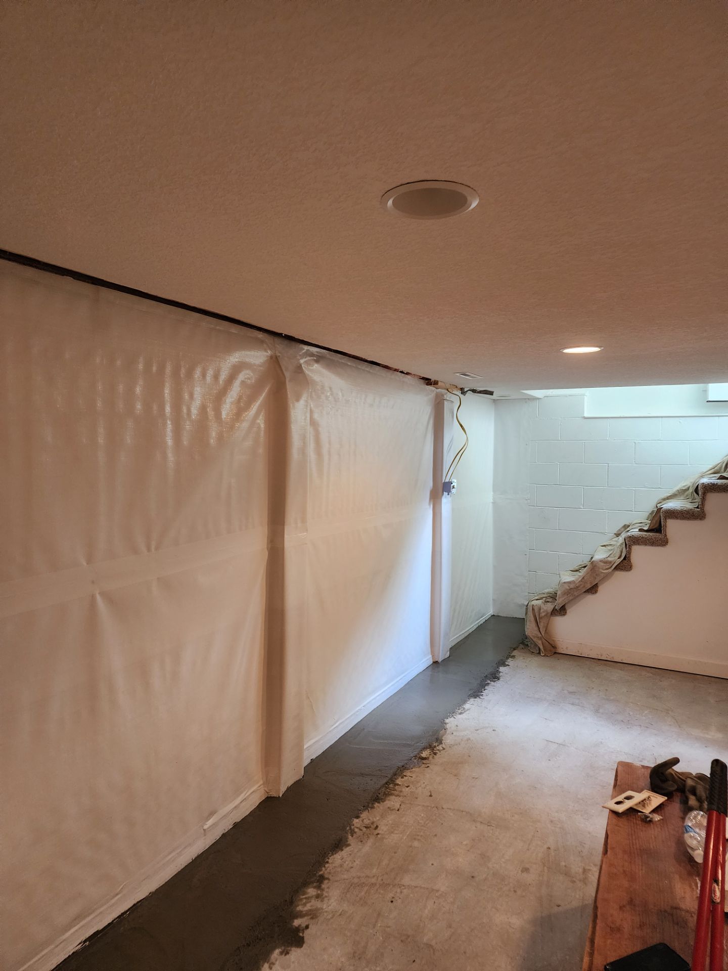 Interior drainage channel and vapor barrier installation